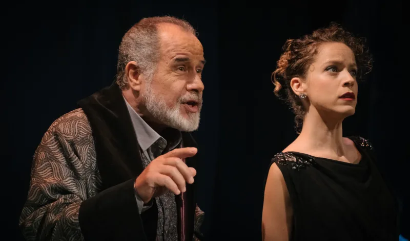 Σκηνή από τη θεατρική παράσταση Dogville με δύο ηθοποιούς.