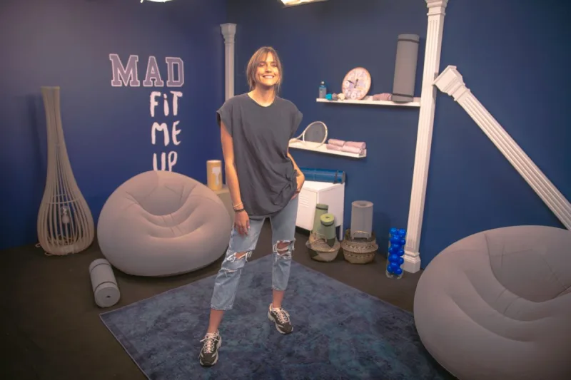 Παρουσιάστρια σε στούντιο του MAD TV με αθλητικό εξοπλισμό και διακόσμηση.