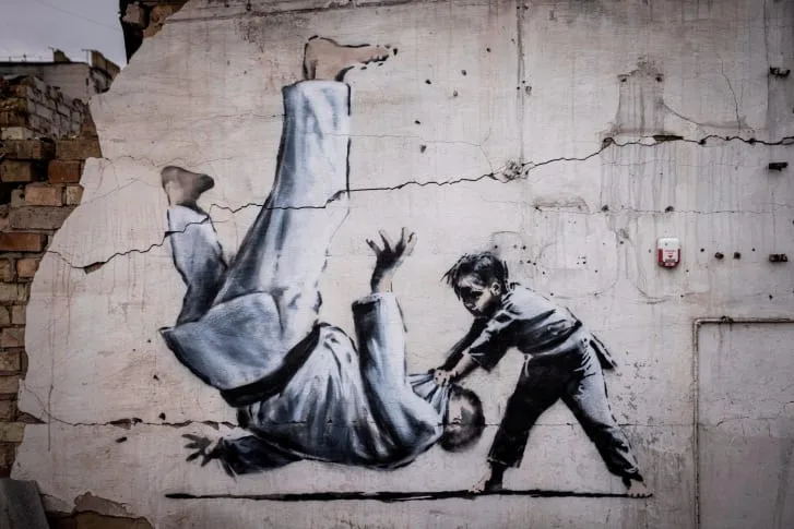 Graffiti του Banksy στην Ουκρανία που δείχνει ένα παιδί να ρίχνει κάτω έναν άνδρα σε αγώνα τζούντο.