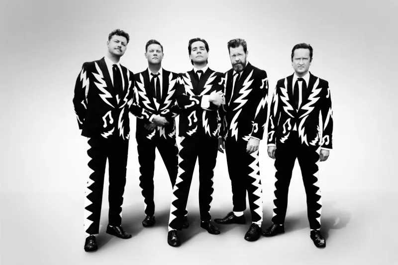 Οι Arctic Monkeys ποζάρουν με ασορτί μαύρα κοστούμια με λευκά σχέδια κεραυνών και μουσικών νοτών.