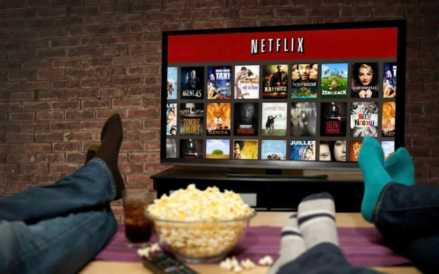 Άτομα παρακολουθούν Netflix σε τηλεόραση με ποπ κορν
