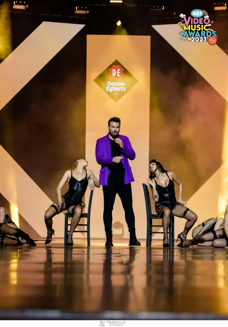 Καλλιτέχνης με μωβ σακάκι στη σκηνή των Mad VMA 2023.