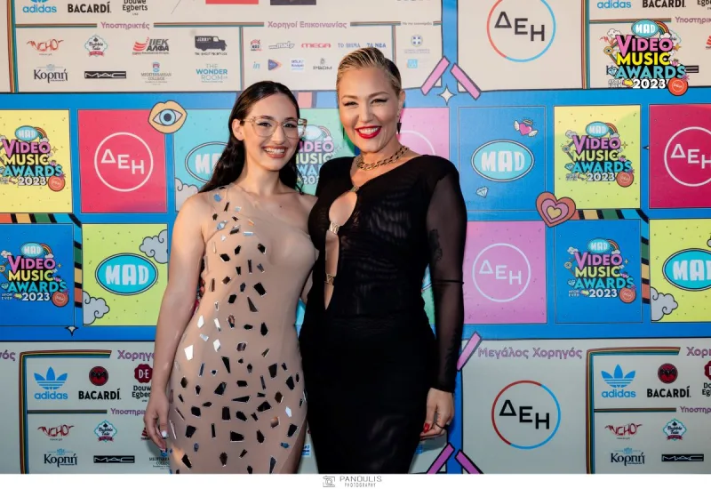 Δύο γυναίκες ποζάρουν στο κόκκινο χαλί των Mad VMA 2023.