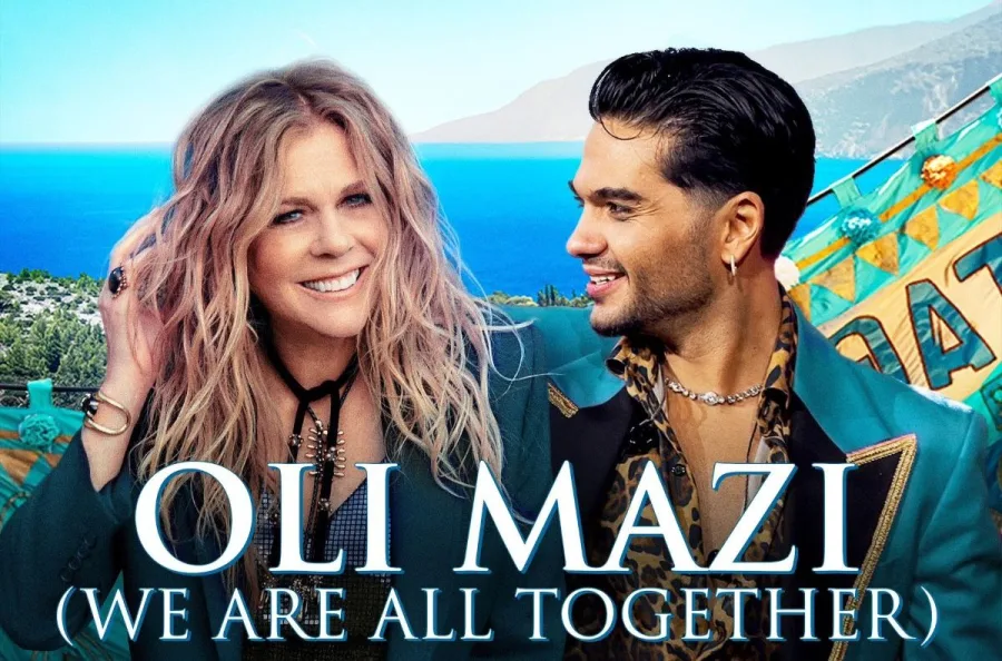 Η Rita Wilson και ο Χρήστος Μάστορας ποζάρουν μαζί με φόντο τη θάλασσα.