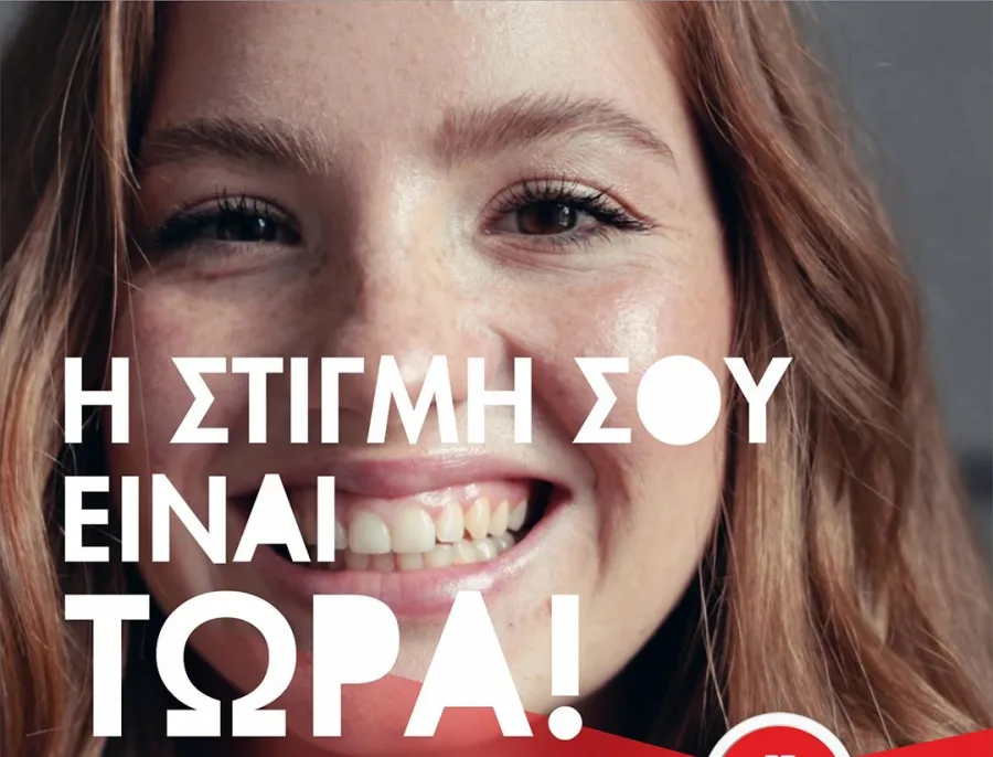 Κοντινό πλάνο μιας χαμογελαστής κοπέλας με φακίδες και κείμενο στα ελληνικά.
