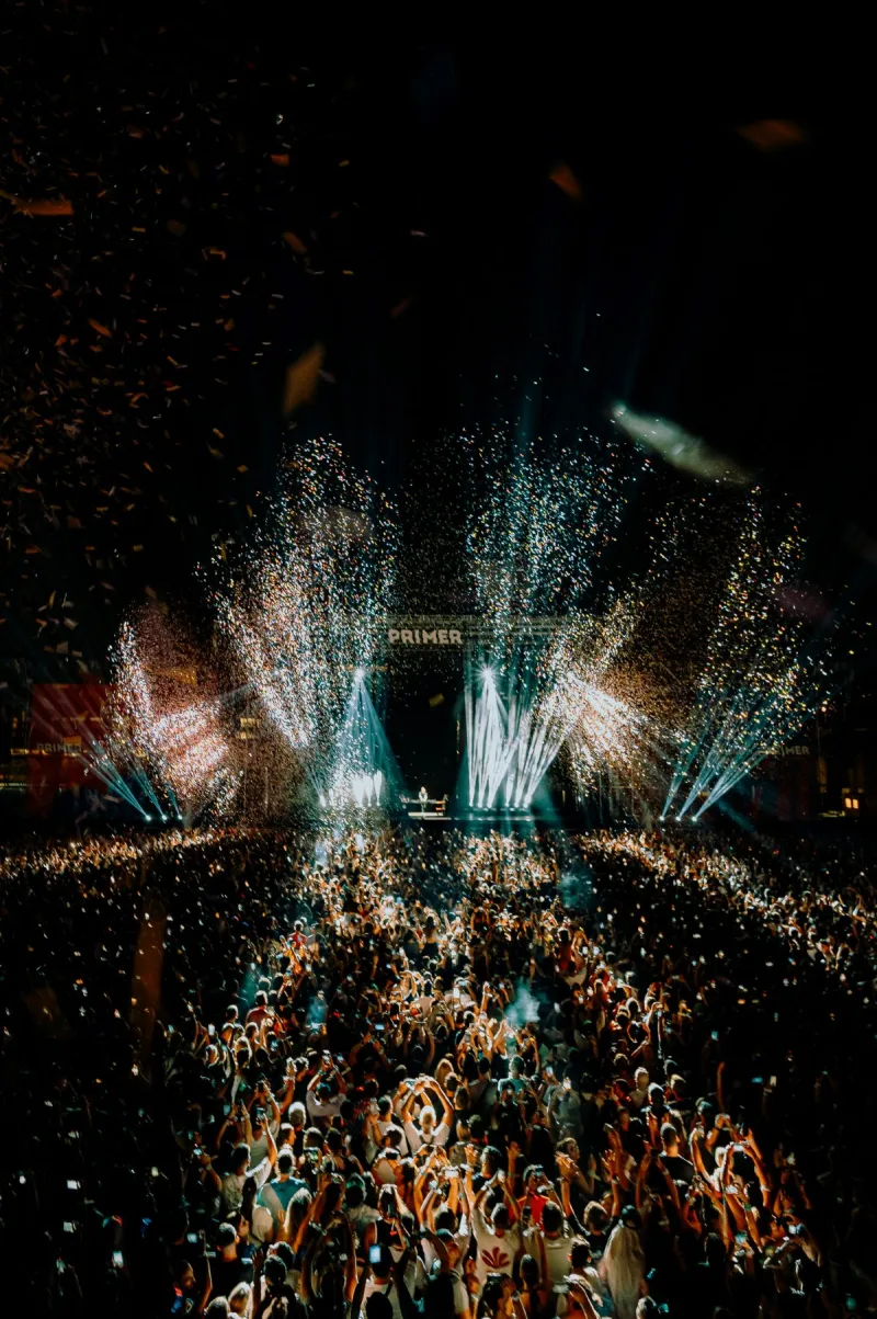 Πανοραμική άποψη του κοινού στο Primer Music Festival με πυροτεχνήματα και κομφετί.