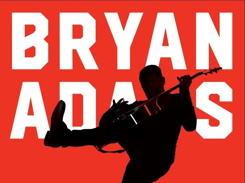 Σιλουέτα του Bryan Adams με κιθάρα σε κόκκινο φόντο.