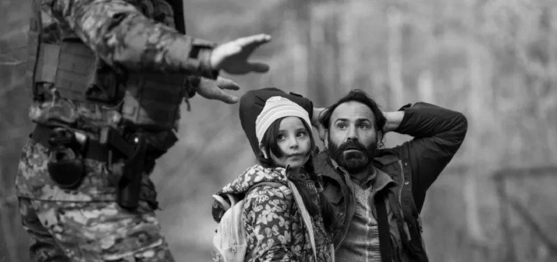 Σκηνή από ταινία με έναν άνδρα, ένα κορίτσι και έναν στρατιώτη στο δάσος.