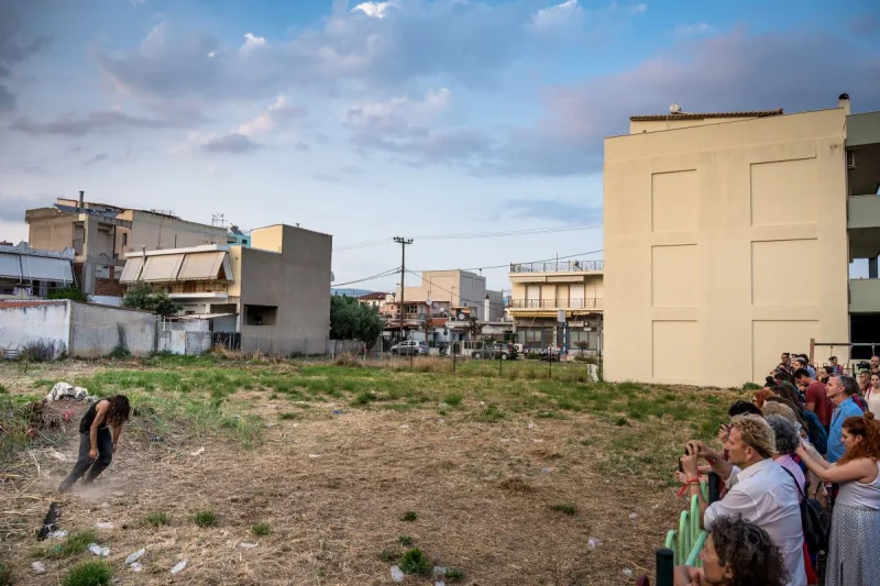 Χορευτής σε υπαίθριο χώρο στην Ελευσίνα με κοινό να παρακολουθεί.