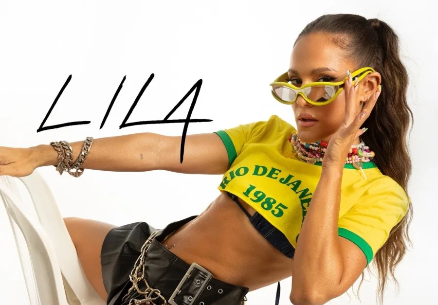 Η τραγουδίστρια LILA ποζάρει με κίτρινο crop top και γυαλιά ηλίου.