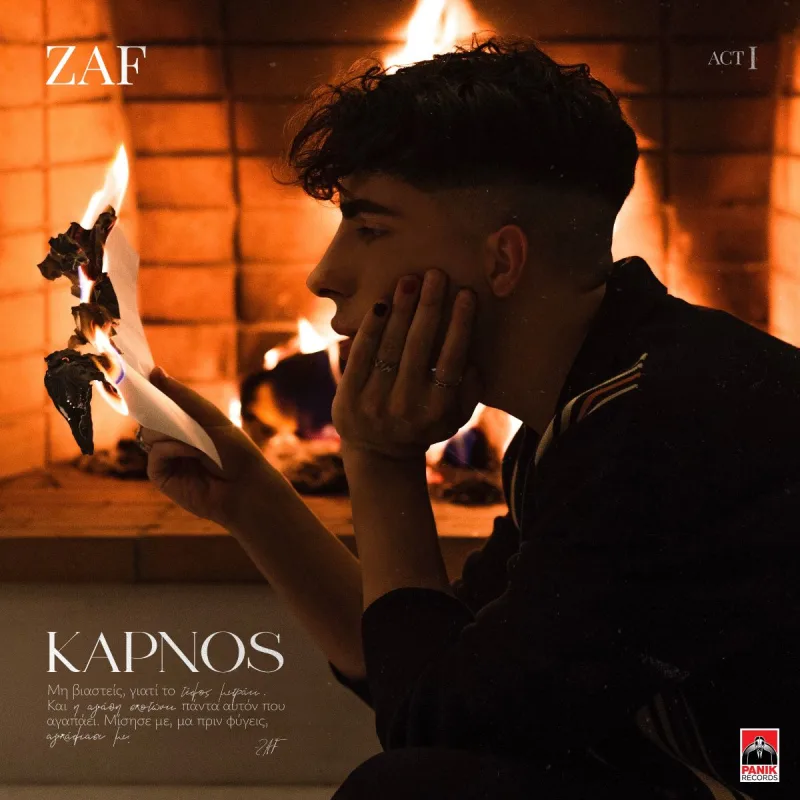 Ο Zaf σε προφίλ μπροστά από τζάκι, κρατώντας ένα χαρτί που καίγεται.