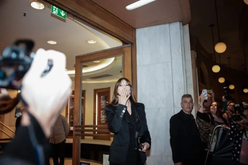 Η Monica Bellucci στέλνει ένα φιλί στο κοινό έξω από κινηματογράφο.