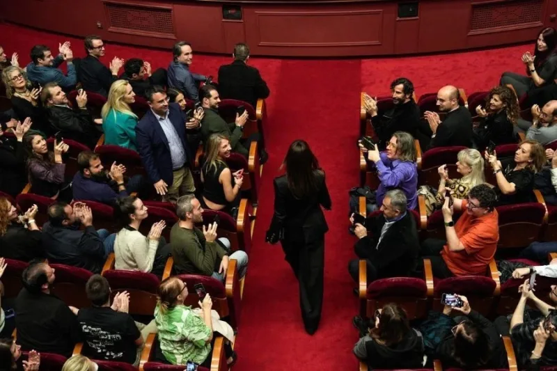 Η Monica Bellucci περπατά ανάμεσα στο κοινό σε κινηματογραφική αίθουσα.