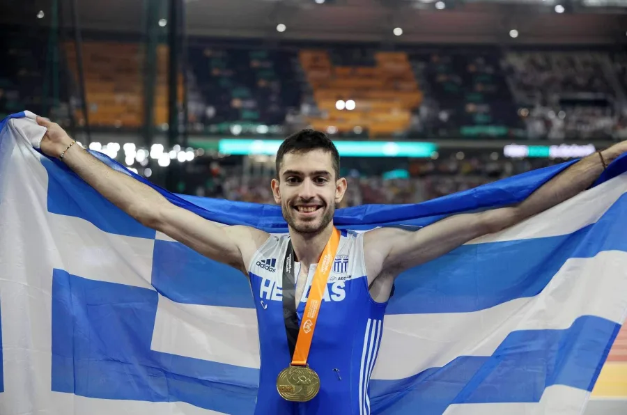 Ο Μίλτος Τεντόγλου πανηγυρίζει με την ελληνική σημαία και το χρυσό μετάλλιο.