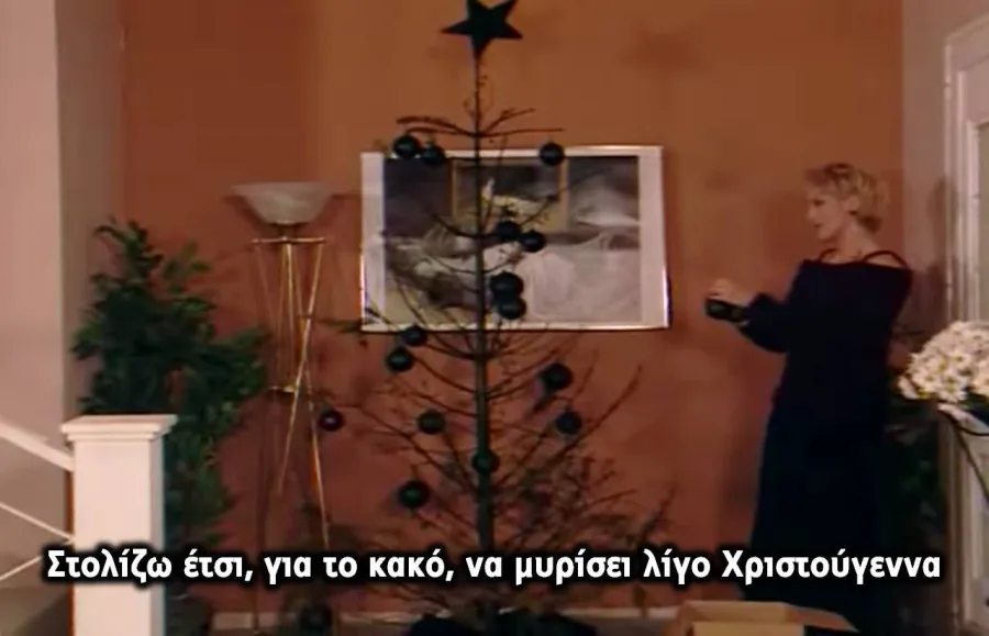 Σκηνή από τη σειρά Κωνσταντίνου και Ελένης με την Ελένη Βλαχάκη να στολίζει ένα λιτό χριστουγεννιάτικο δέντρο.