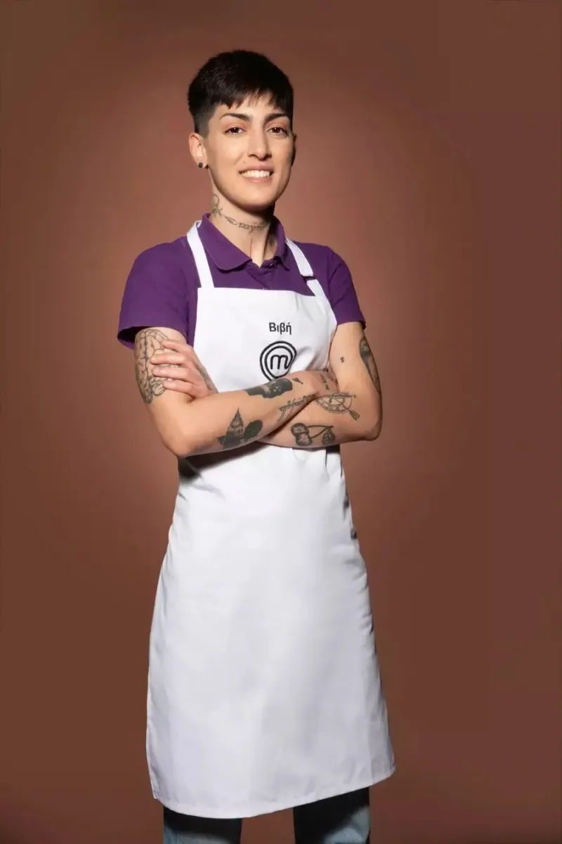 Μια παίκτρια του MasterChef με λευκή ποδιά και τατουάζ στα χέρια.