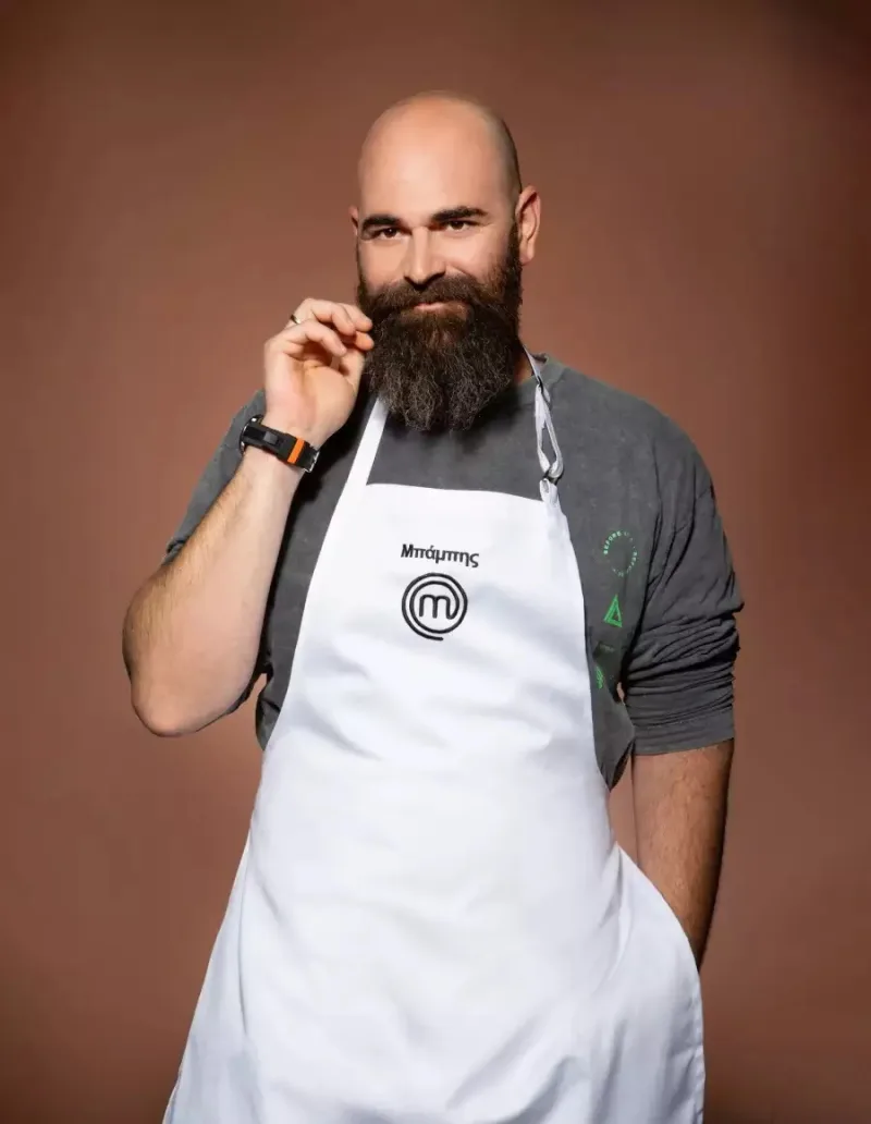 Ο Μπάμπης από το MasterChef με λευκή ποδιά και γκρίζα μπλούζα.