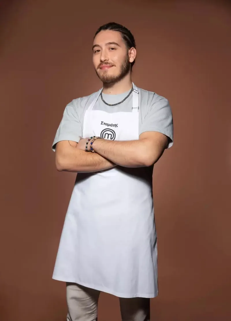 Ο Σταμάτης, παίκτης του MasterChef, ποζάρει με λευκή ποδιά και σταυρωμένα χέρια.