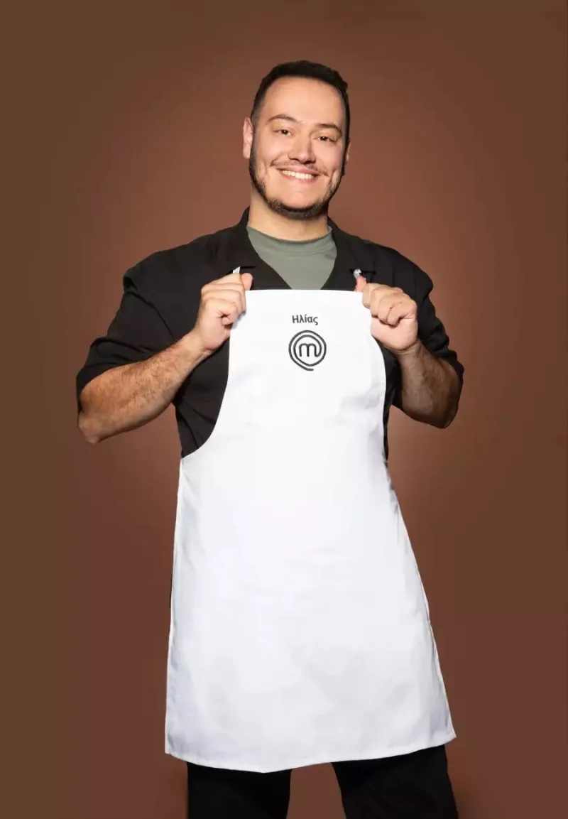 Ο Ηλίας από το MasterChef ποζάρει με τη λευκή ποδιά του διαγωνισμού.