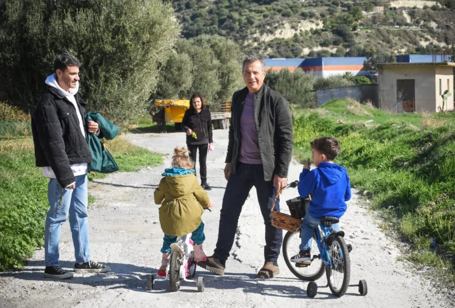 Ο Παντελής Τουτουντζής με τον σύντροφό του και τα δύο τους παιδιά σε εξωτερικό χώρο.