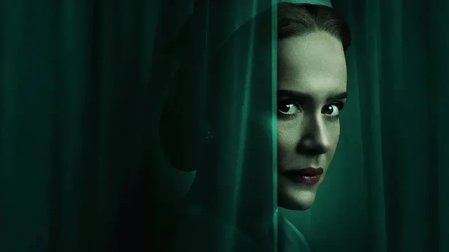 Η Sarah Paulson ως Ratched πίσω από μια πράσινη κουρτίνα.