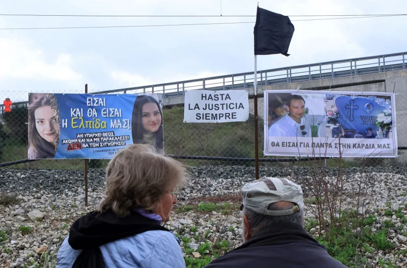 Πανό με φωτογραφίες θυμάτων και μήνυμα για δικαιοσύνη στο σημείο της τραγωδίας στα Τέμπη.