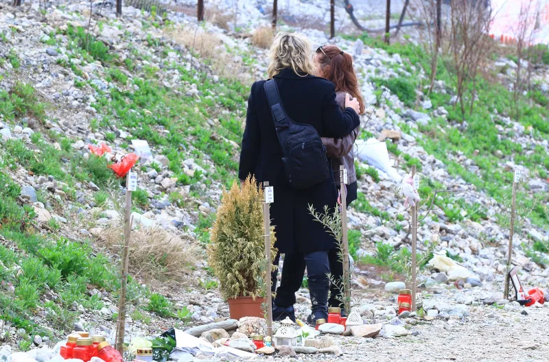 Δύο γυναίκες αγκαλιασμένες σε σημείο μνήμης στα Τέμπη.