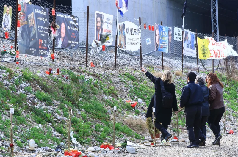 Άνθρωποι αποτίουν φόρο τιμής στο σημείο της τραγωδίας στα Τέμπη.