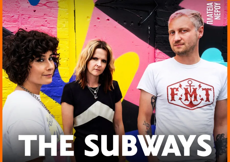 Το συγκρότημα The Subways ποζάρει μπροστά από έναν πολύχρωμο τοίχο.