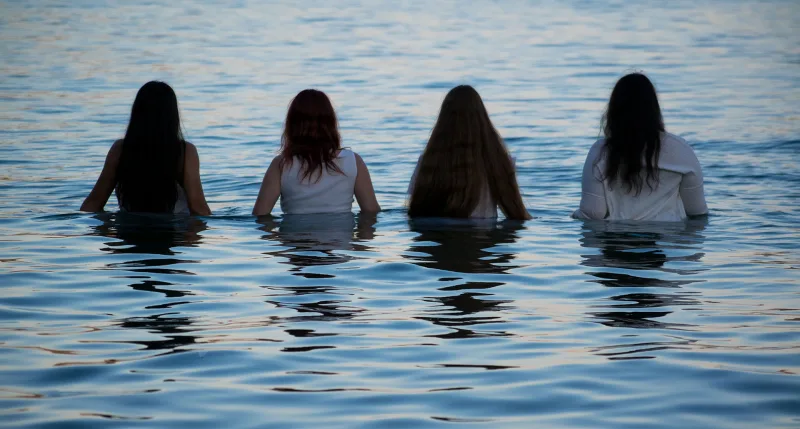 Τέσσερις γυναίκες με λευκά ρούχα μέσα στη θάλασσα