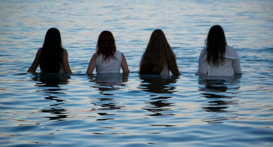 Τέσσερις γυναίκες με λευκά ρούχα μέσα στη θάλασσα