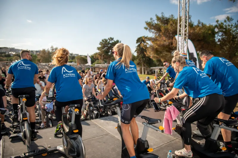 Άνθρωποι σε στατικά ποδήλατα στο Athens Fitness Festival.