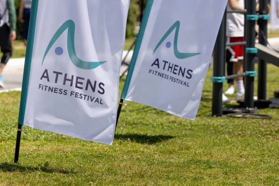 Σημαίες με το λογότυπο του Athens Fitness Festival σε γρασίδι.