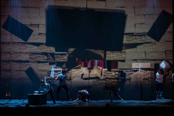 Σκηνή από την παράσταση The Wall - Pink Floyd's Rock Opera με χορευτές και προβολές.
