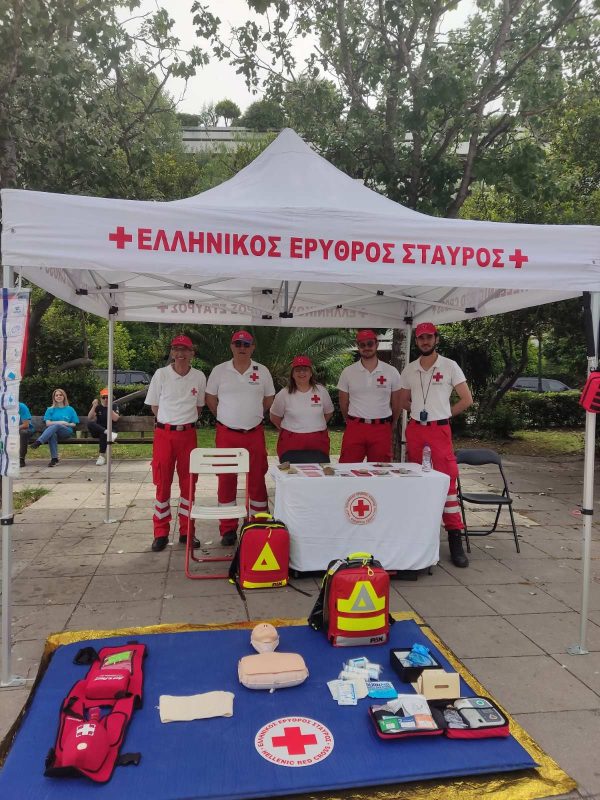 Εθελοντές του Ελληνικού Ερυθρού Σταυρού σε περίπτερο με εξοπλισμό πρώτων βοηθειών.