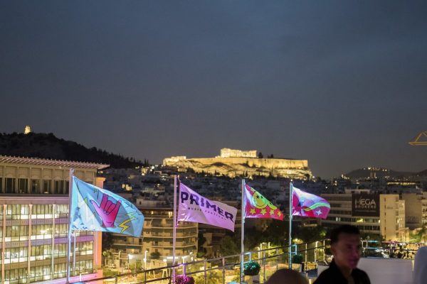Σημαίες του Primer Music Festival σε ταράτσα με θέα την Ακρόπολη στην Αθήνα.