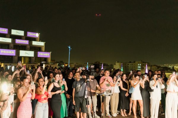 Πλήθος κόσμου σε εκδήλωση του Primer Music Festival σε ταράτσα τη νύχτα.