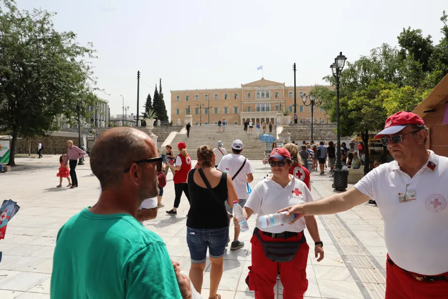 Εθελοντές του Ελληνικού Ερυθρού Σταυρού μοιράζουν νερά στην Πλατεία Συντάγματος.