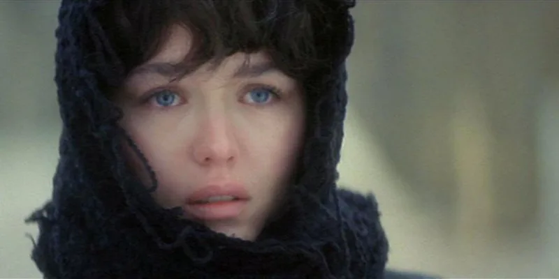 Κοντινό πλάνο γυναίκας με γαλάζια μάτια και μαύρο πλεκτό μαντήλι στο κεφάλι.