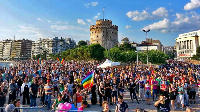 Πλήθος κόσμου με σημαίες Pride μπροστά από τον Λευκό Πύργο στη Θεσσαλονίκη.