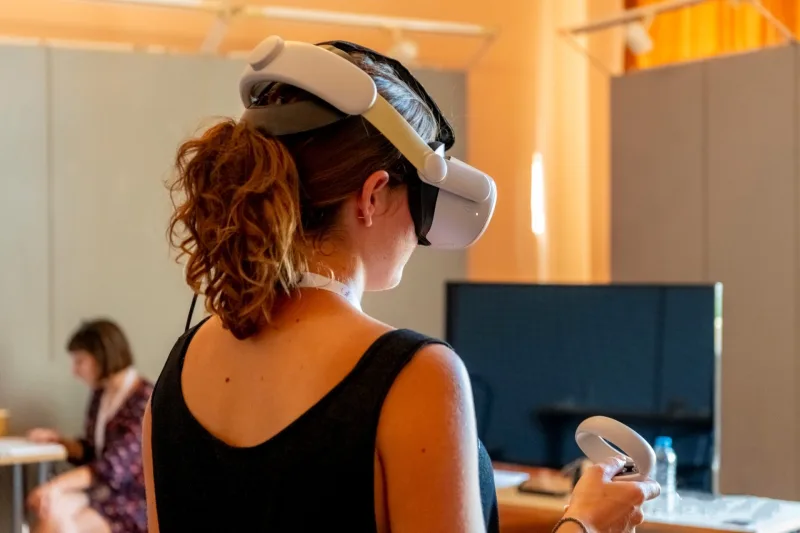 Γυναίκα φοράει VR headset και κρατάει χειριστήριο στο Animasyros.