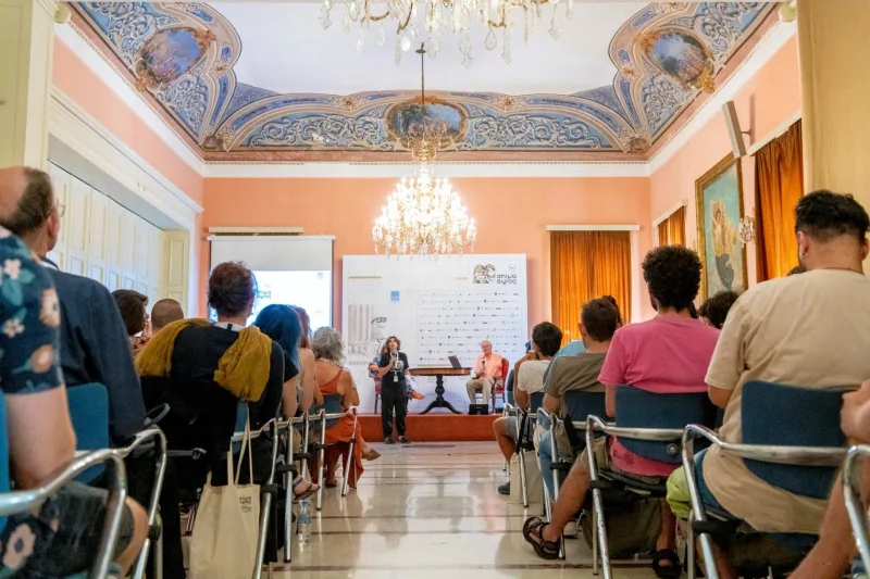Στιγμιότυπο από το φεστιβάλ Animasyros σε αίθουσα με κοινό και ομιλητές.