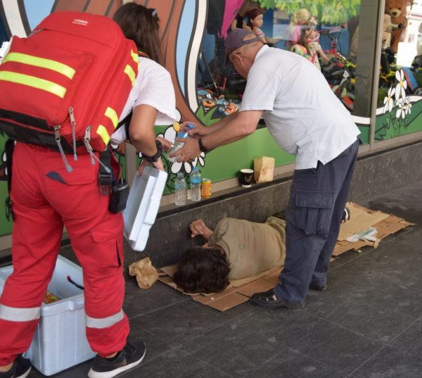 Εθελοντές του Ελληνικού Ερυθρού Σταυρού προσφέρουν βοήθεια σε άστεγο άνδρα στο κέντρο της Αθήνας.