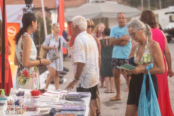 Κόσμος σε υπαίθριο πάγκο ενημέρωσης κατά την έναρξη του 9ου Beyond Borders.