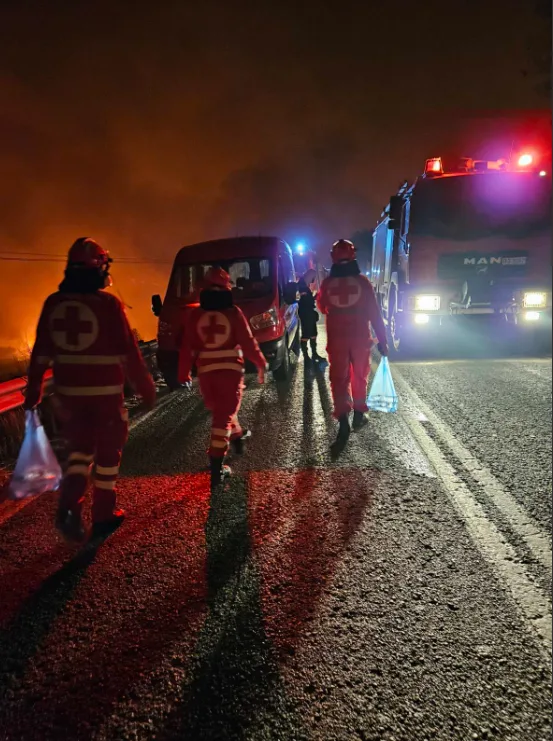 Εθελοντές του Ελληνικού Ερυθρού Σταυρού σε νυχτερινή επιχείρηση με οχήματα.
