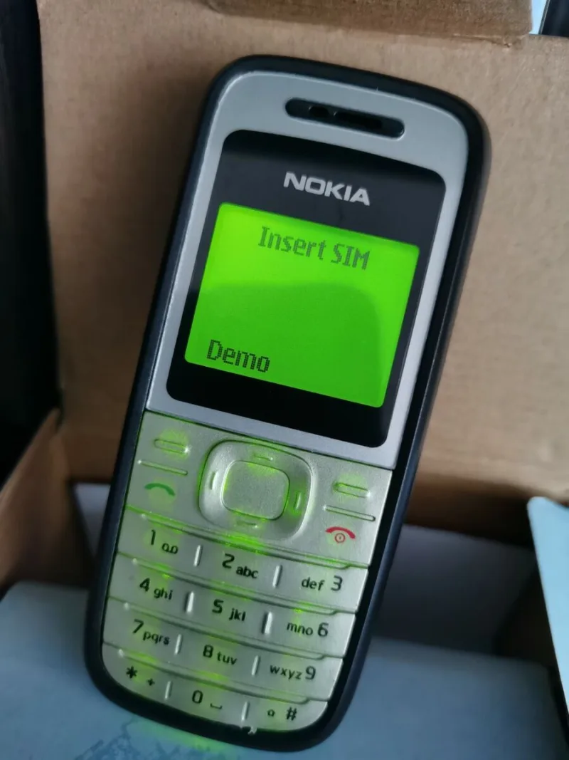 Κλασικό κινητό τηλέφωνο Nokia με πράσινη φωτιζόμενη οθόνη και πληκτρολόγιο.