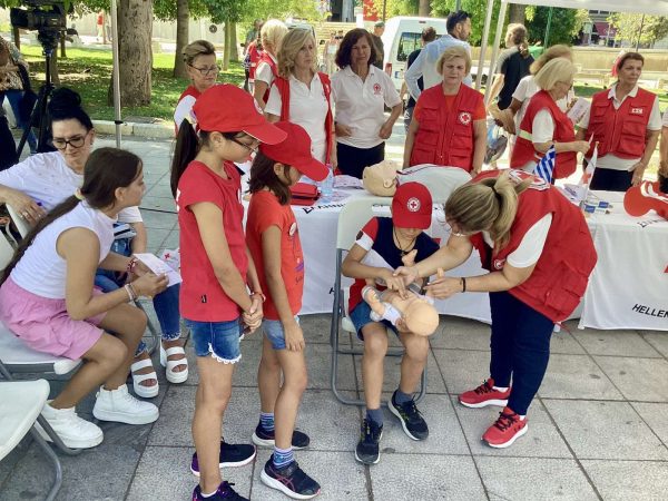 Εθελόντριες του Ελληνικού Ερυθρού Σταυρού εκπαιδεύουν παιδιά στις πρώτες βοήθειες στην Πλατεία Συντάγματος.