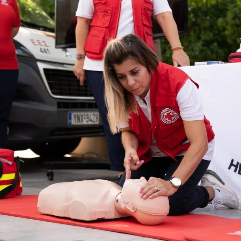 Εθελόντρια του Ελληνικού Ερυθρού Σταυρού πραγματοποιεί επίδειξη πρώτων βοηθειών σε πρόπλασμα.