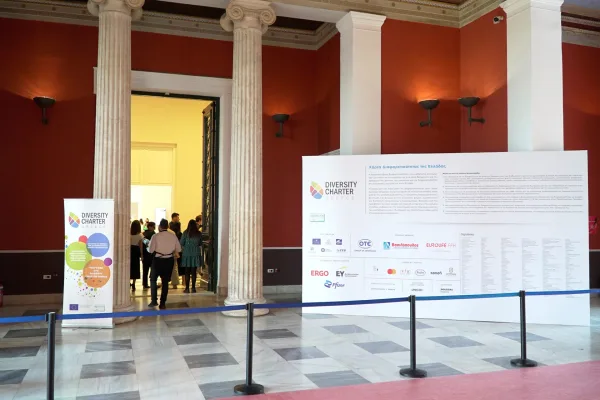 Είσοδος εκδήλωσης για το Diversity Charter Greece με μεγάλες αφίσες και κίονες.