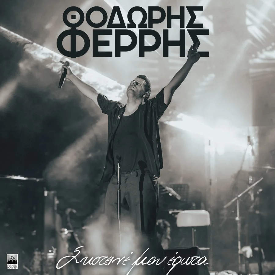 Ο Θοδωρής Φέρρης σε ασπρόμαυρη φωτογραφία πάνω στη σκηνή με τα χέρια ανοιχτά.